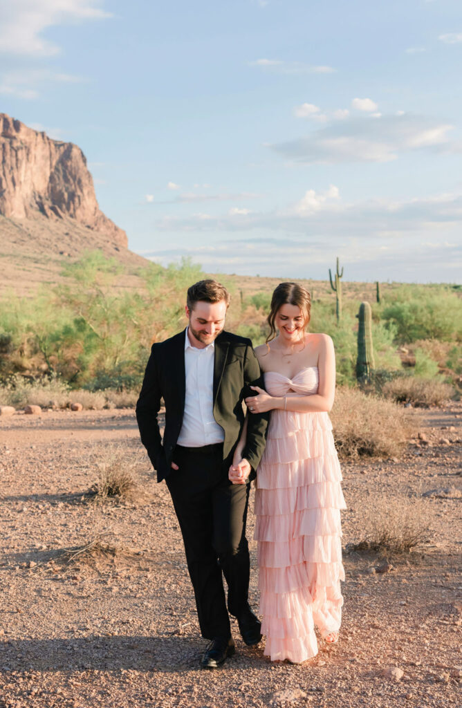 Couple holding hands on the desert trail at Lost Dutchman State Park during their Phoenix engagement session.