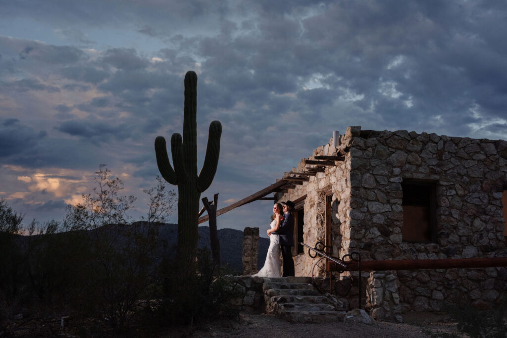 Bride resting her head on the groom’s shoulder as the sun sets, creating a warm, cinematic wedding portrait.