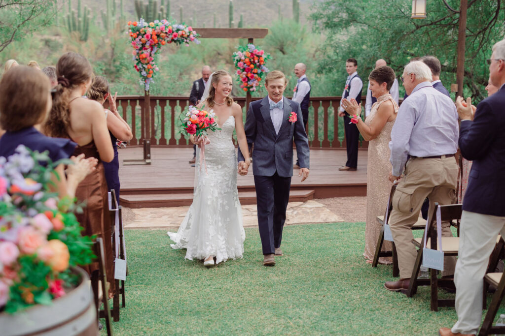 Bride & groom walking done the aisle for their recessional after the first kiss at Tanque Verde Ranch.