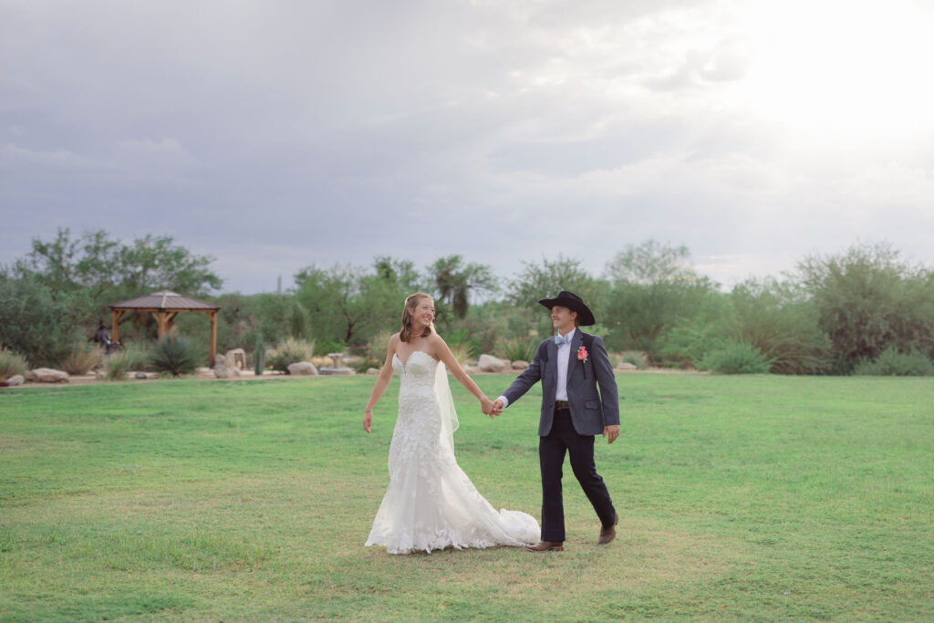 Romantic sunset photo of the couple holding hands in soft, glowing light captured by a destination wedding photographer.