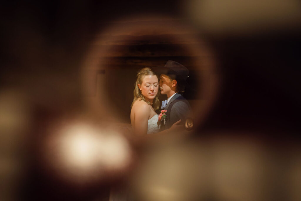 Newlyweds listening to speeches during their evening reception, surrounded by family and friends.