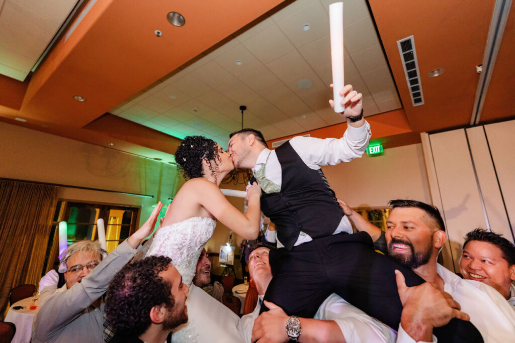Guests pick up bride and groom for a epic dance floor shot.