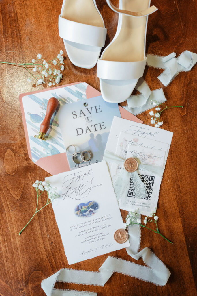 3. Close up of invitation suite, rings, and florals styled on a linen surface at Hacienda Del Sol.