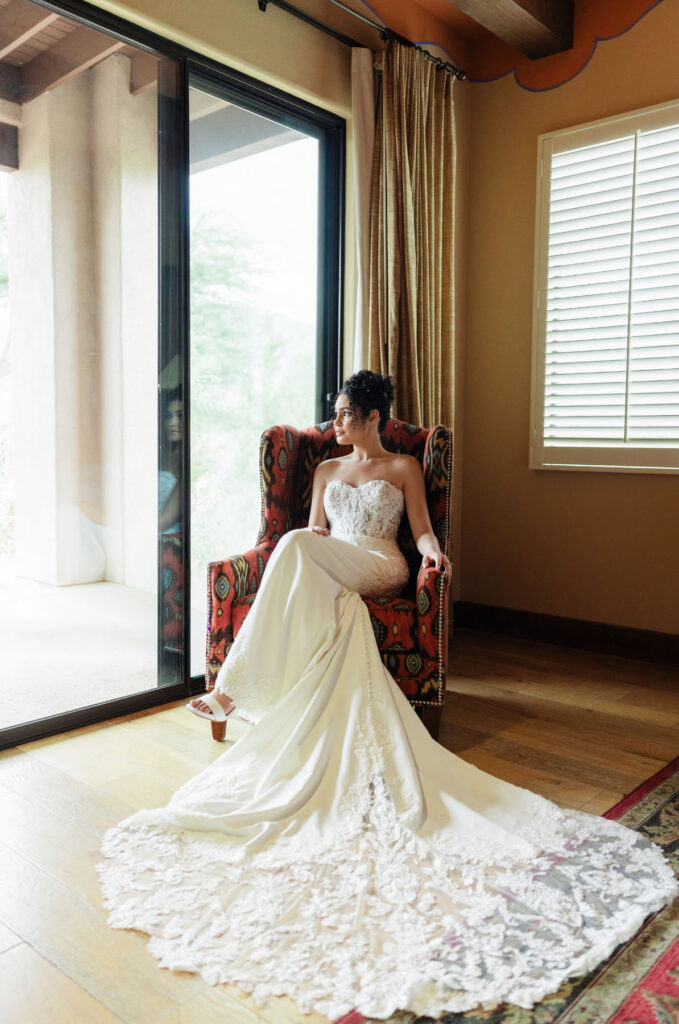 Wedding dress hanging against a textured wall in a luxury Tucson resort room.
