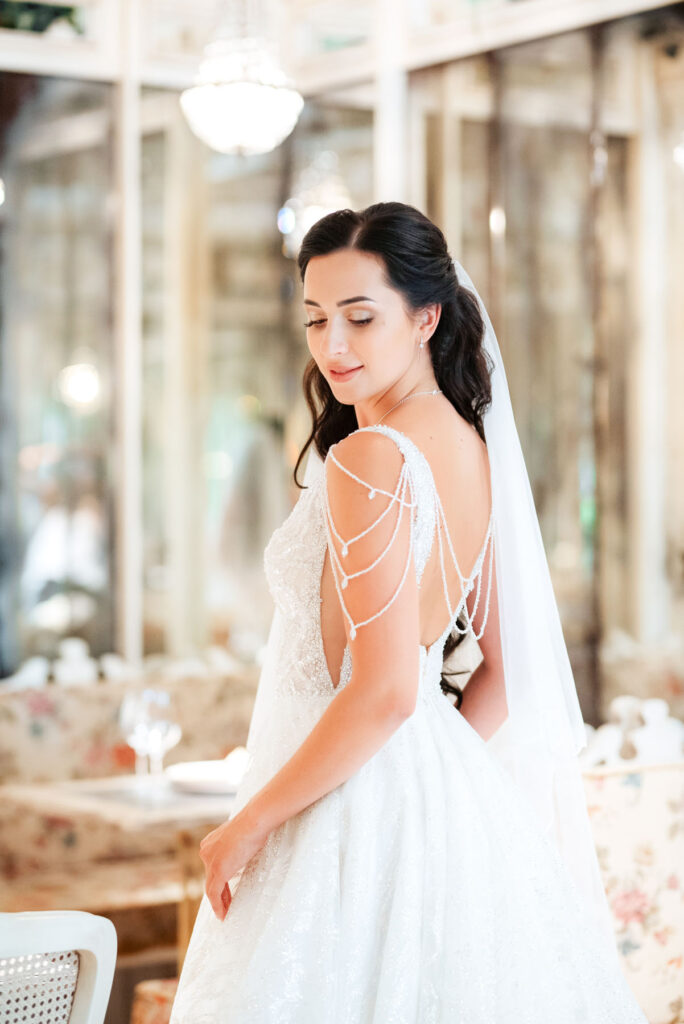 portrait of a bride in a white dress in a bright cafe with mirrors