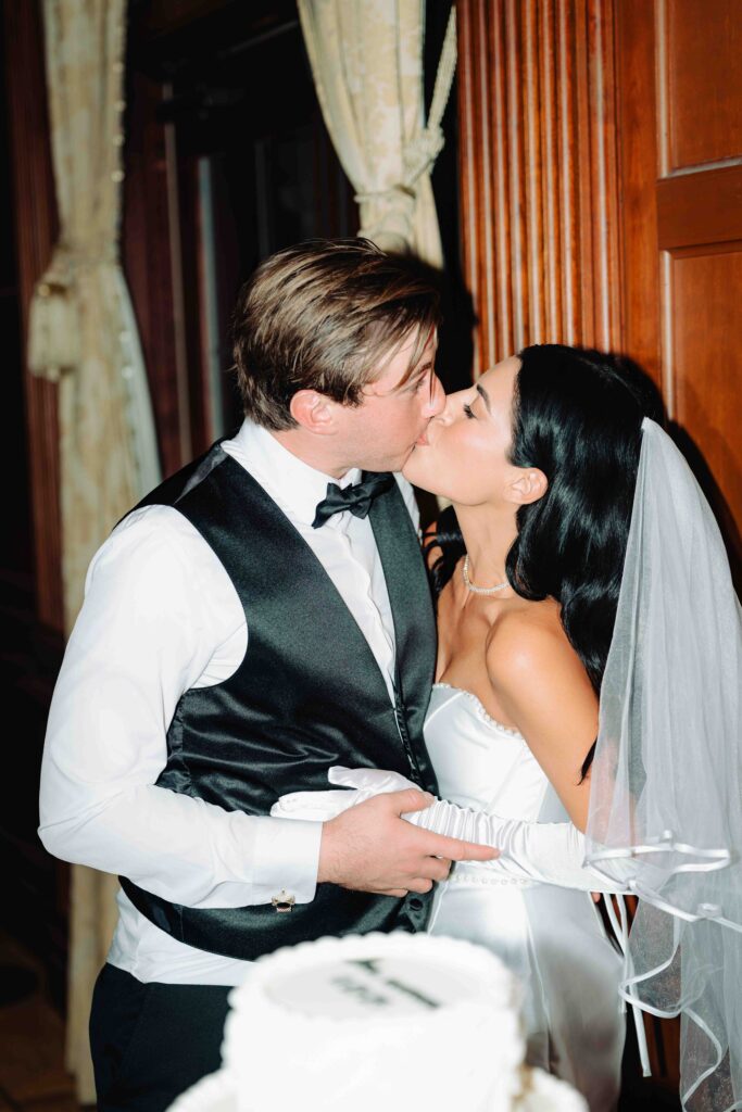 A bride and groom kiss during their wedding reception at the indoor reception space Villa Siena in Arizona.  